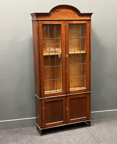 Lot 626 - An oak glazed two door bookcase with arched...