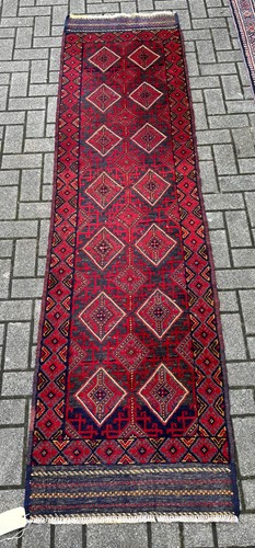Lot 711 - A Persian geometric pattern wool runner in...