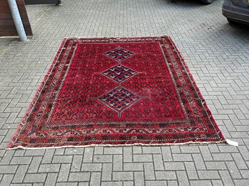 Lot 713 - A Persian Shiraz carpet mainly reds, the...