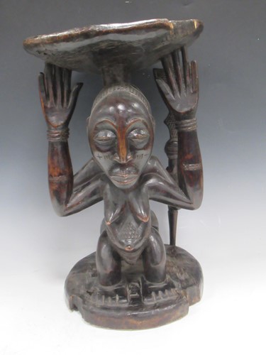 Lot 32 - A Luba Hemba carved stool, the circular top...