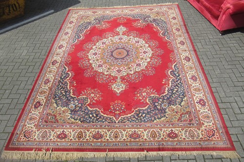 Lot 699 - A Persian Tabriz style red ground rug with...