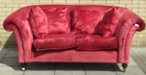 Lot 635 - A red velvet type two seater scroll arm sofa...
