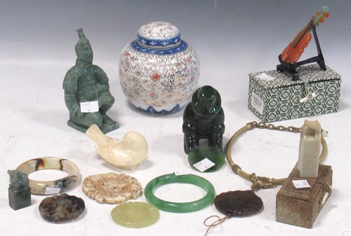 Lot 130 - A green mottled jade figure of a gold...