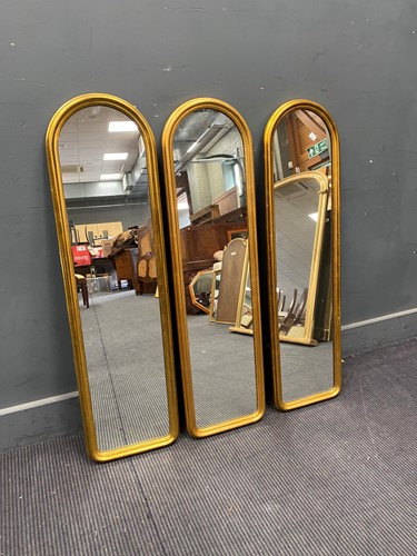 Lot 740 - Three gilt arched length mirrors, 105cm x 29cm