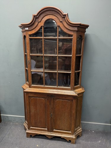 Lot 680 - A Dutch oak glazed top cabinet of shaped arch...