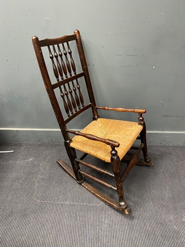 Lot 427 - An spindle back rocking chair with rush seat...