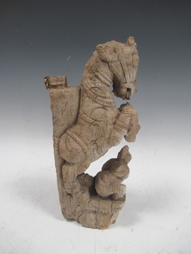 Lot 23 - A carved wood fragment of an Indian war horse...
