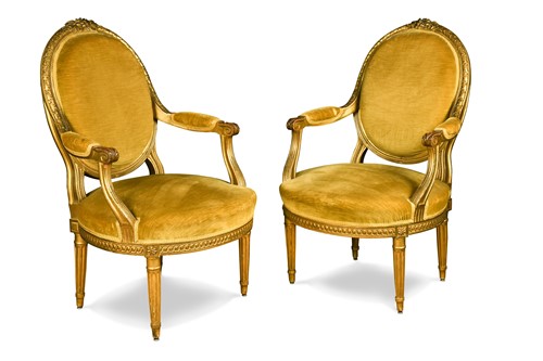 Lot 578 - A pair of French Louis XVI style carved giltwood armchairs, 20th century