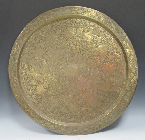 Lot 247 - A large round brass tray with engraved floral...