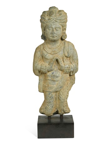 Lot 144 - A Gandharan style carved grey schist standing figure of a man wearing a turban