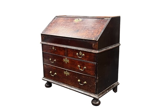 Lot 514 - An early 18th century oak slope front bureau,...