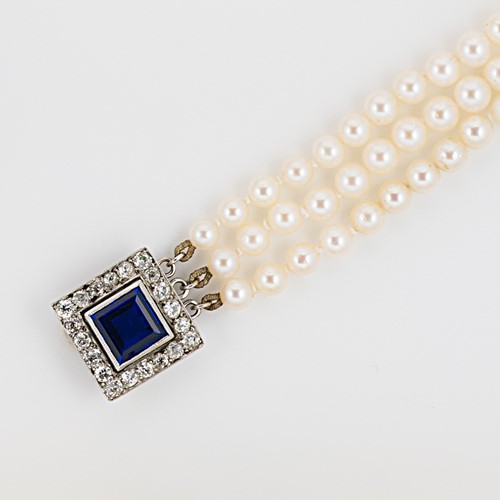 Lot 18 - A three row cultured pearl necklace with a stone set clasp