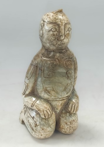 Lot 36 - A Chinese 'chicken bone' jade kneeling figure, in archaic style