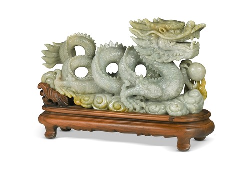 Lot 24 - A Chinese carved jade figure of a coiled dragon, 20th century