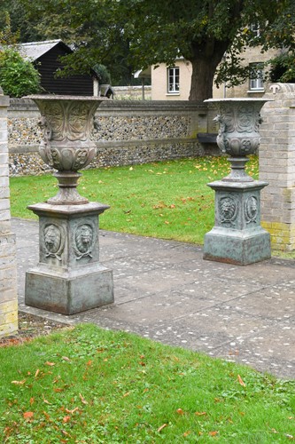 Lot 701 - A pair of verdigris patinated cast iron Bordeaux urns on plinths, modern
