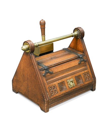 Lot 188 - In the manner of Christopher Dresser, an Arts & Crafts oak coal scuttle and shovel