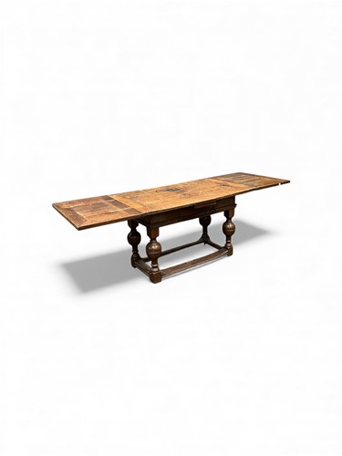 Lot 362 - A 17th century style oak extending draw leaf...