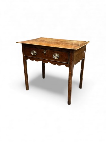 Lot 690 - A George III oak side table, with single long...