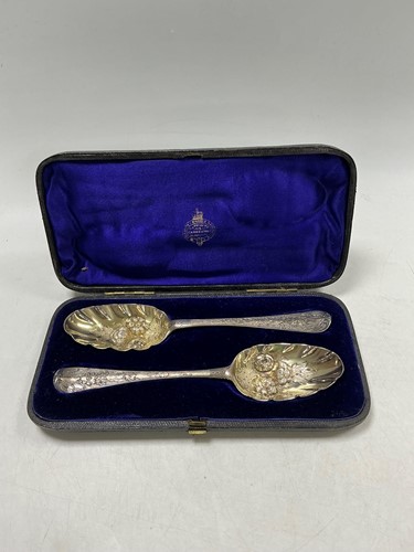 Lot 299 - A cased pair of George II silver berry spoons...