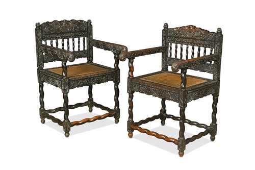 Lot 580 - A near pair of carved ebonised armchairs, Ceylon, late 17th century