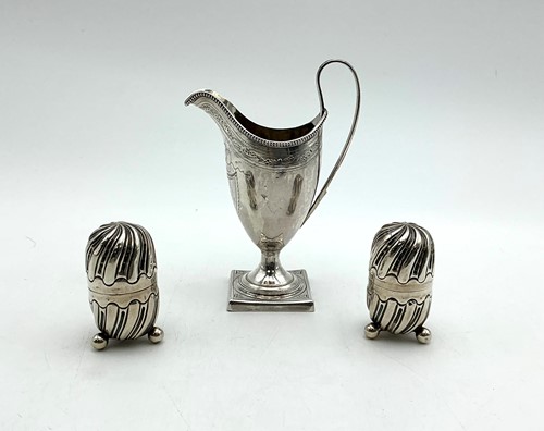 Lot 17 - A cream jug, together with a pair of pepperettes