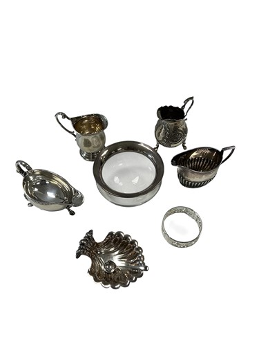 Lot 334 - A small silver sauce boat and three milk jugs,...