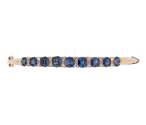 Lot 217 - An Edwardian sapphire and diamond hinged bangle