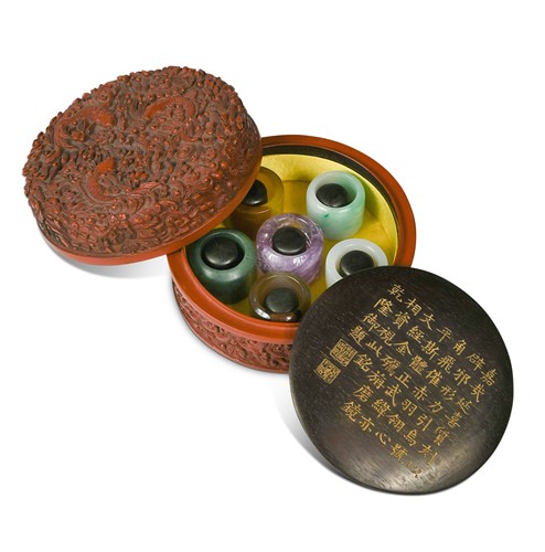 Lot 53 - A cinnabar lacquer boxed set of six hardstone archer's rings