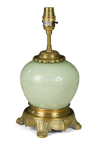 Lot 472 - A crazed-celadon and gilt-metal lamp, early 20th century