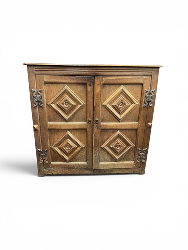 Lot 373 - A carved two door panelled oak side cabinet,...
