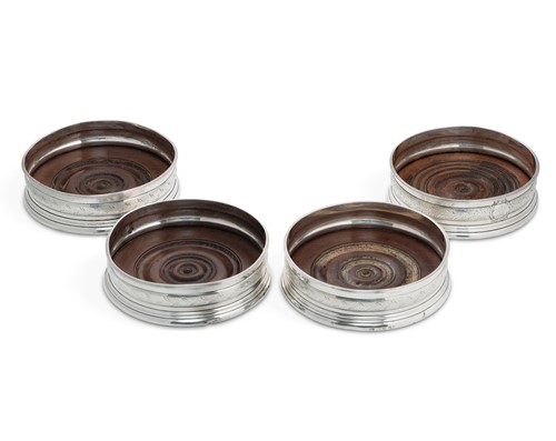 Lot 337 - A set of four George III silver wine/bottle coasters
