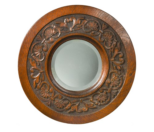 Lot 172 - Attributed to Simpson of Kendal, a carved oak circular mirror