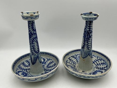 Lot 74 - Two Chinese blue and white candlestands, with...
