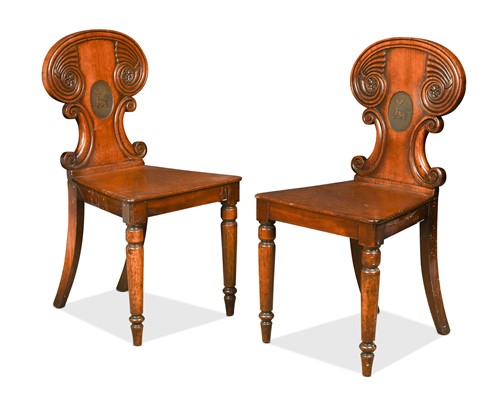 Lot 563 - A pair of late Regency mahogany armorial hall chairs