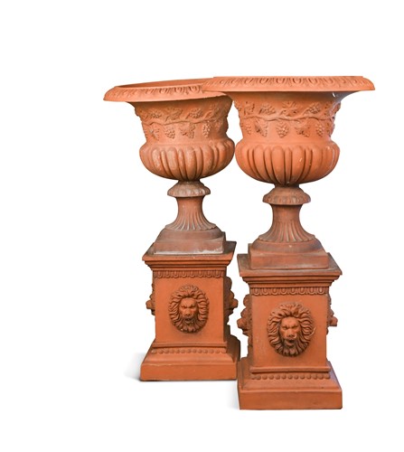 Lot 725 - A pair of terracotta urns on plinths, early 20th century