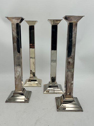 Lot 169 - A set of four silverplated table candlesticks...