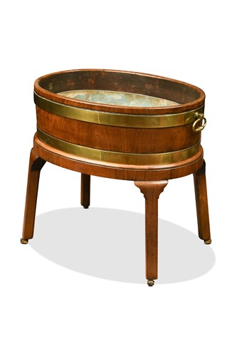 Lot 473 - A George III oval mahogany brass bound wine cooler on stand