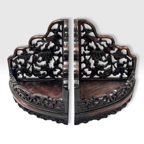 Lot 47 - A pair of Chinese carved pierced hardwood corner shelves, circa 1900