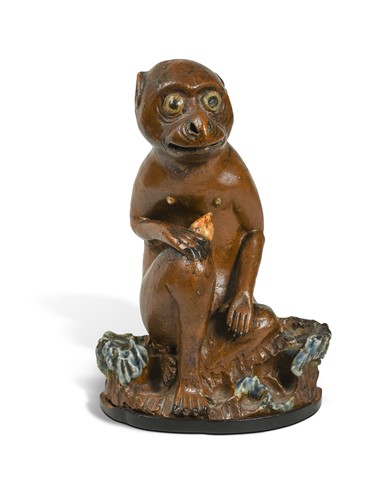 Lot 68 - An Asian ceramic monkey, seated eating a nut, late 19th / early 20th century