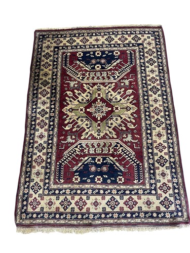 Lot 803 - A Kazak wool rug, burgundy ground with central...
